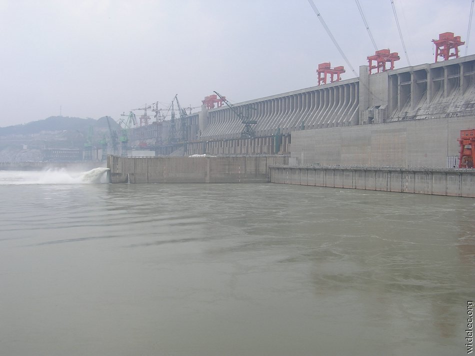 Люди перегородили реку большой плотиной вода выше. Санься ГЭС. Три ущелья ГЭС. Асуанский гидроузел. Плотина 3 ущелья.