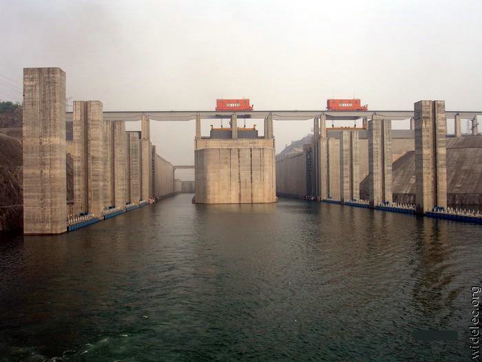 Люди перегородили реку большой плотиной вода выше. Санься ГЭС Китай. Плотина три ущелья в Китае. Самая большая ГЭС В мире три ущелья. Дамба в Китае.